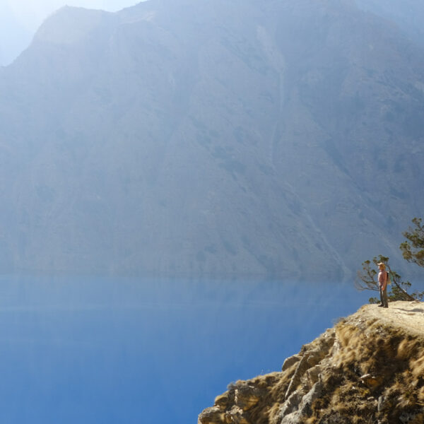A small trekker in the grand landscape at the Phoksundo lake in Dolpo