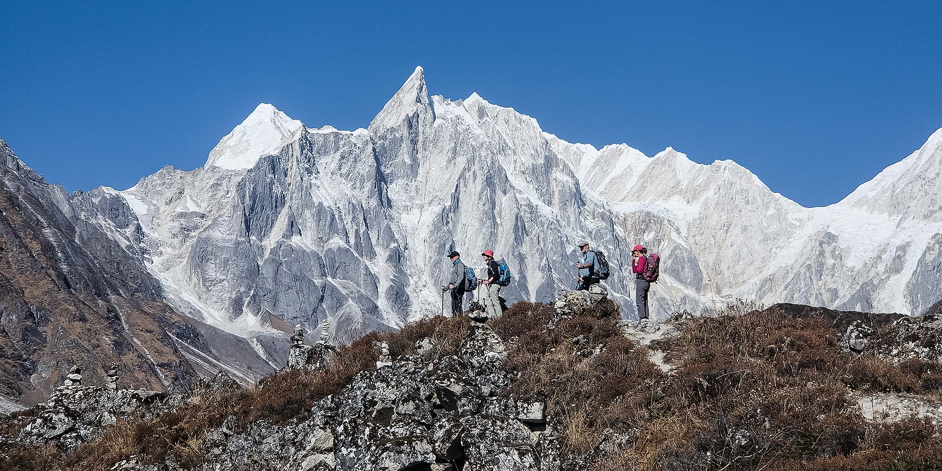 Trekkers enjoying the view near Ponkar Lake on the Manaslu circuit trek in Nepal. Nimjung 7140m can be seen in the background